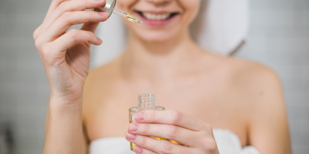 Woman using a dropper to apply skincare oil