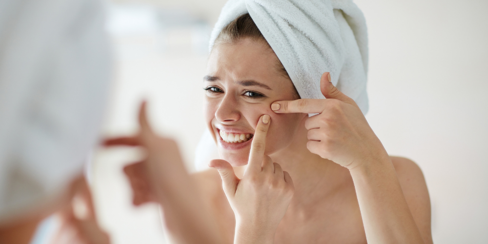 Woman examining her skin in the mirror
